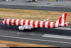 a red and white plane is on the runway