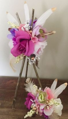 flowers and feathers are arranged on top of sticks