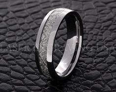 a wedding ring with an intricate design on the outside and inside, sitting on a black surface