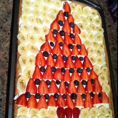 a cake decorated with bananas and strawberries in the shape of a christmas tree