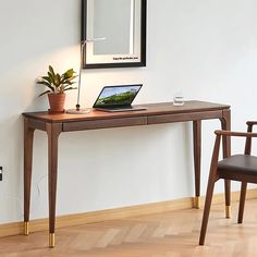 a laptop computer sitting on top of a wooden desk next to a chair and mirror