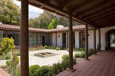 an outdoor courtyard with brick pavers and potted plants