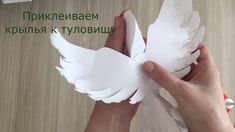 someone is making a paper bird with white feathers