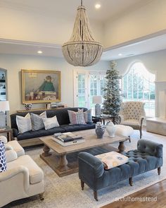 a living room filled with furniture and a chandelier hanging over the top of it