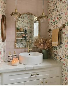 a bathroom sink sitting under a mirror next to a wall mounted faucet with lights on it