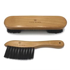 two wooden brushes sitting next to each other on a white surface with the words cue - king written on it