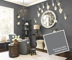 a living room with gray walls and white furniture in the corner, along with an ornate chandelier