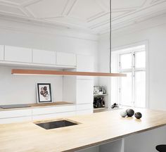 a kitchen with white cabinets and wooden counter tops, along with a sink in the center