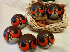 four birds painted on chocolate eggs in a basket with twine baskets around them and one bird sitting on top of the eggs