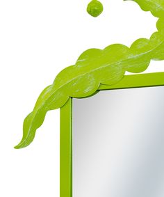 a green frame with a leaf on top and a mirror in the middle that is reflecting it's image