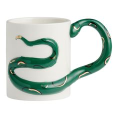 a white and green mug with a snake design on it