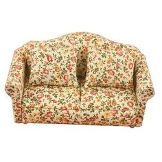 an old fashioned couch with floral fabric on the back and arms, sitting against a white background