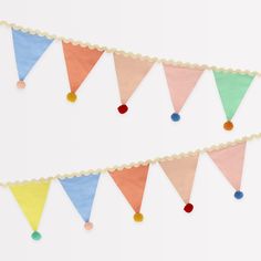 two paper buntings that have been decorated with pom poms