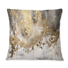 a decorative pillow with gold and silver paint splattered on it's side