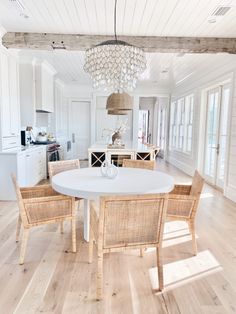 a dining room table with chairs and a chandelier hanging from it's ceiling