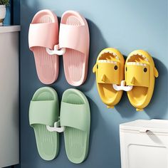 three pairs of shoes hanging on the wall next to a washer