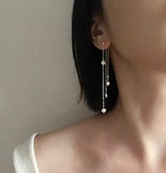 a close up of a person wearing some kind of earring with pearls on it