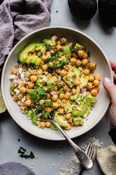 a white bowl filled with chickpeas, avocado and cilantro