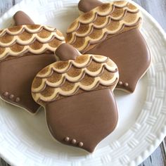 three decorated cookies sitting on top of a white plate