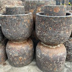 old pots are stacked on top of each other in the middle of an outdoor area