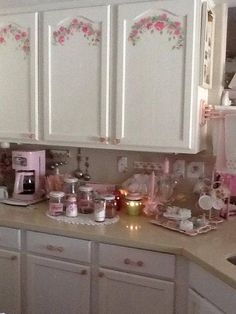 a kitchen with white cabinets and pink flowers on the backsplash, along with other appliances