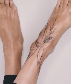 a woman's foot with tattoos on it and her hand holding the other leg