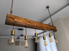 a wooden beam with five light bulbs hanging from it