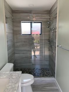 a white toilet sitting next to a walk in shower