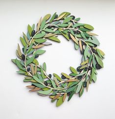 a wreath made out of green leaves and olives