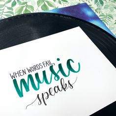 a sign that says when words fail music speaks on it next to a vinyl record