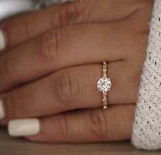 a woman's hand with a diamond ring on it