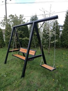 a wooden swing set in the grass