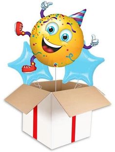 a birthday balloon in the shape of a smiley face sitting on top of a box