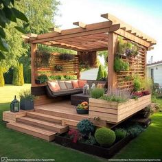 a wooden gazebo sitting on top of a lush green field next to a garden