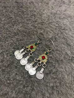 Moroccan Silver EnamelBerber Handmade Earrings with old coins and green-red glass. Enamel Venetian green, yellow. Handmade Moroccan silver crafted earrings. The earrings feature fantastic wirework with mint green, golden yellow. These are light and easy to wear. These earrings are individually hand made and slight variations in workmanship and enamel are normal. Good Condition and 100% handmade item. Length : 8,5cm Width : 2cm Weight : 18,3g Bohemian Meenakari Metal Earrings, Bohemian Enamel Jewelry, Vintage Green Earrings For Festival, Bohemian Enamel Pierced Jewelry, Vintage Green Festival Earrings, Festive Silver Enamel Jewelry, Bohemian Green Enamel Earrings, Bohemian Enamel Earrings Nickel Free, Bohemian Enamel Earrings Nickel-free