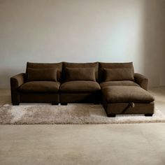 a brown sectional couch sitting on top of a white rug in a living room next to a window