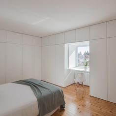 a bedroom with white walls and wooden floors