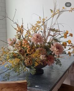 a vase filled with lots of flowers on top of a table