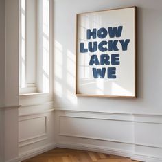 an empty room with a framed poster on the wall and wooden flooring in front of it