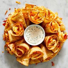 an overhead view of some taco shells with ranch dressing on the side and sauce in a small bowl