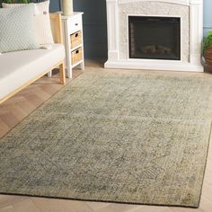 a living room with a couch, fireplace and rugs on the floor in front of it