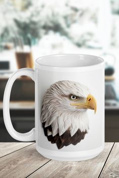 a coffee mug with an eagle's head painted on the front and side, sitting on a wooden table