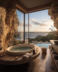 a bathroom with a large jacuzzi tub next to a window overlooking the ocean