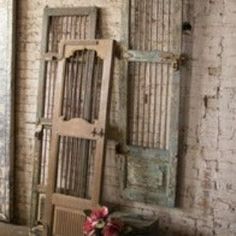 an old wooden door sitting on top of a hard wood floor next to a flower pot