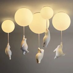 some white lights hanging from the ceiling with animals on them and balloons in the air