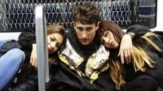 three young people are sitting together on a bus