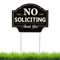 a no soliciting sign sitting on top of a green grass covered field with the words thank you