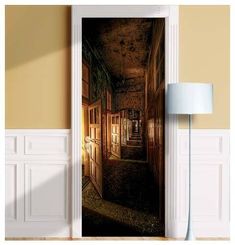 an open door leading to a hallway with lights on the wall and a lamp next to it