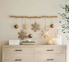 a white dresser topped with lots of drawers next to a vase filled with flowers and candles