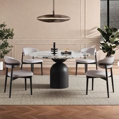 a dining room table with four chairs and a vase on the floor next to it